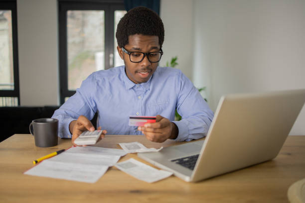 istock Cheerful man doing online shopping 1496507822