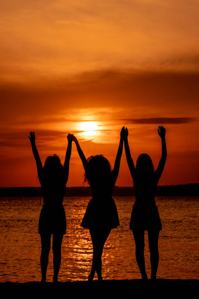 istock silhouette of three girlfriends on the beach 1496509668