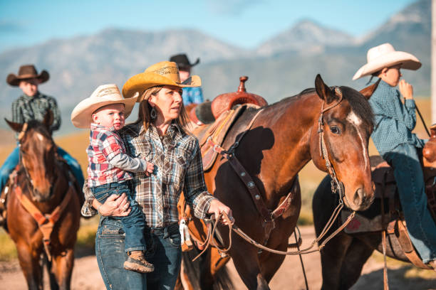 istock Responsible Mother Guiding a Horse while Holding her Child 1496510042