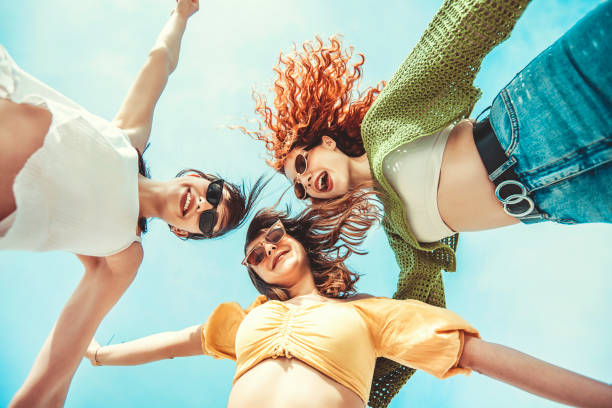 três namoradas se divertindo com as mãos para cima - sunglasses women smiling portrait - fotografias e filmes do acervo