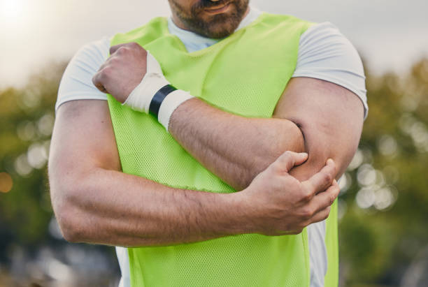 rugby, pain and man with elbow injury on sports field after practice match, training and game outdoors. medical emergency, accident and male athlete with joint inflammation, arm sprain and tendinitis - playing field effort outdoors human age imagens e fotografias de stock