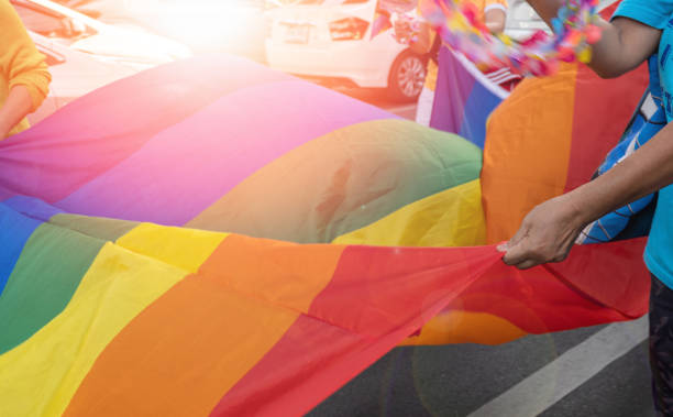 istock People carrying LGBTQ flag and colours 1496516863