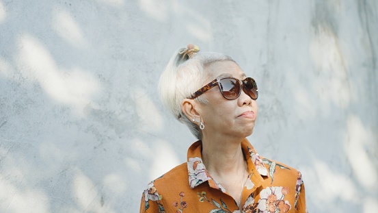 Active Asian senior woman with sunglasses in young at heart cool attitude