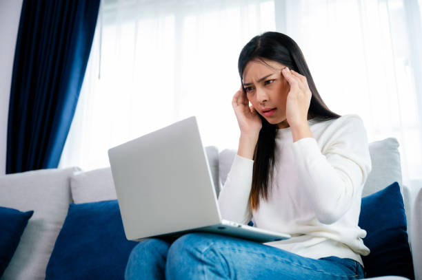 istock Office syndrome. Overworked tired young asian woman feeling headache, having eyesight problem after computer laptop work. Stressed young woman suffering from fatigue at home 1496520611