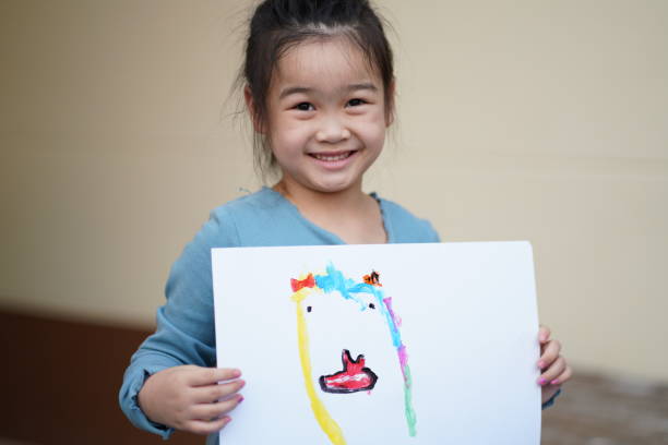 istock little girl proudly present her paint by water color, Weekend activity for developing kid while stay at home 1496522839