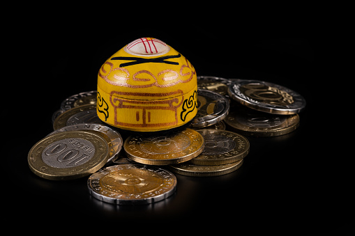 A symbolic Kazakh yurt, the traditional dwelling of nomads, on a pile of Kazakh coins in denominations of 100 and 200 tenge on a black background