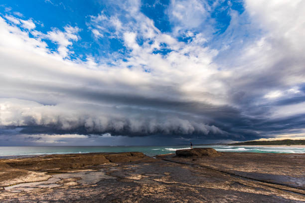 istock Dramatic shelf cloud storm system coming in to coast with onlooker 1496524052