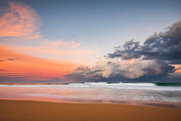 istock Coastal seascape of dramatic storm cell system over ocean illuminated by sunset 1496524917