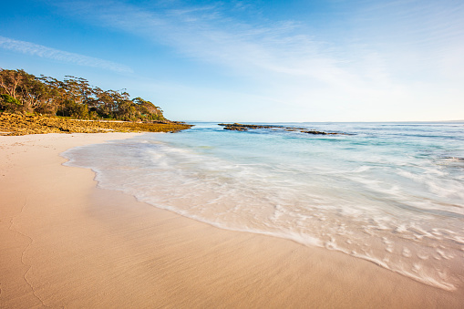 Tidal patterns from wave on white sand beach on a summers day with clear blue sky. Photographed at Hyams Beach, NSW, Australia.