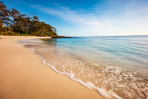 Tidal patterns from wave on white sand beach on a summers day with clear blue sky. Photographed at Hyams Beach, NSW, Australia.