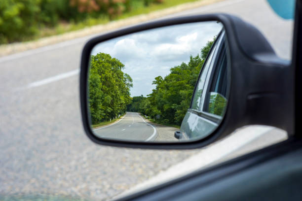 istock Side view mirror of a two lane road in the forest 1496533510