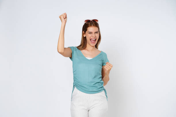 istock Young woman with raised hands celebrating success isolated on white background. 1496534379