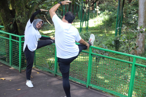 istock Instructor guide young woman stretching legs 1496535370