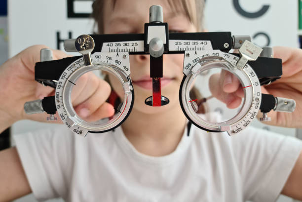 istock Child holding trial frame for medical optician concept in clinic. 1496536346