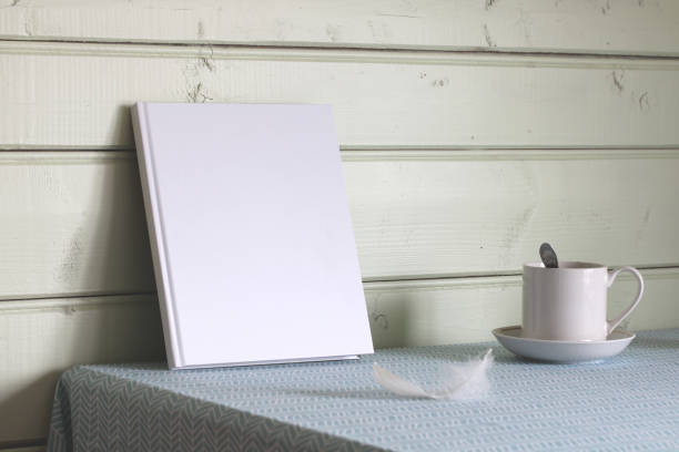 istock A book with an empty cover and a white mug on the table with a tablecloth. Mockup, a place for your text. Country interior. 1496538089