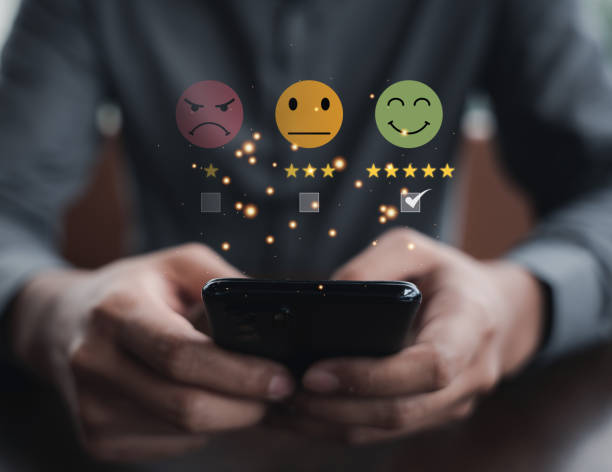 istock Close-up of man's hand using smartphone to rate service with 5-star feedback icon 1496540801