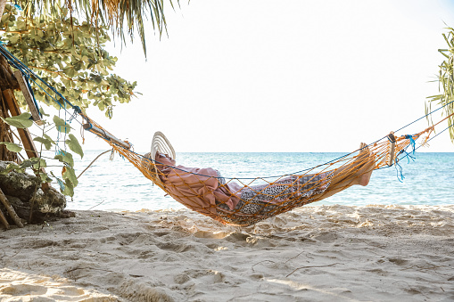 Woman relaxing on hammock at the beach
