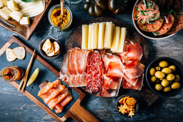 Appetizers with different antipasti, charcuterie, snacks, meat platter with cheese and spicy olives, salmon carpaccio