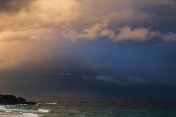 Dark moody, energetic storm cloud system illuminated by last light of day.