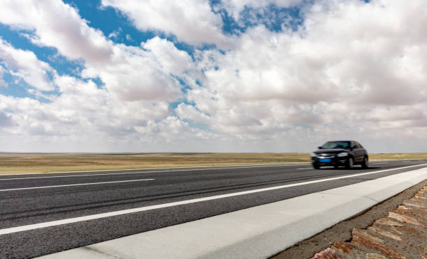 istock car coming from far away on the road 1496557252