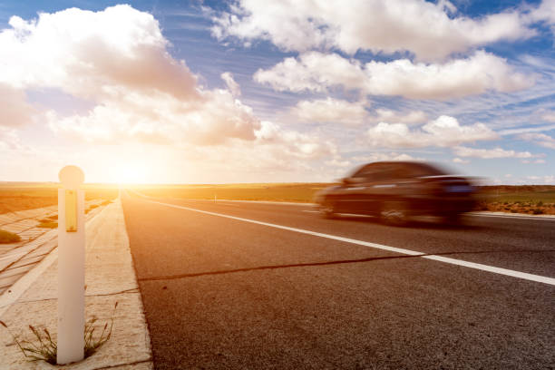 istock black car fast passing the road 1496557403