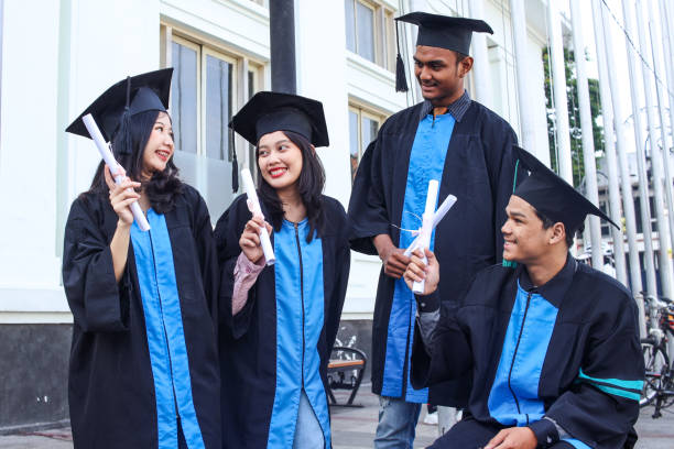 istock Smiling graduates standing together outdoors 1496557471