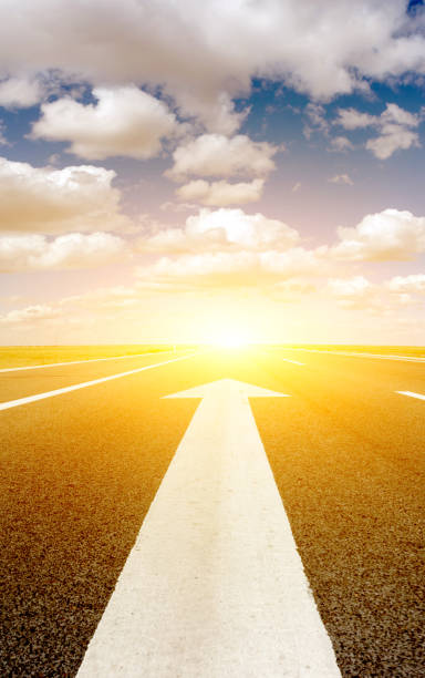 istock The ahead arrow on the asphalt road and sunset background 1496559248