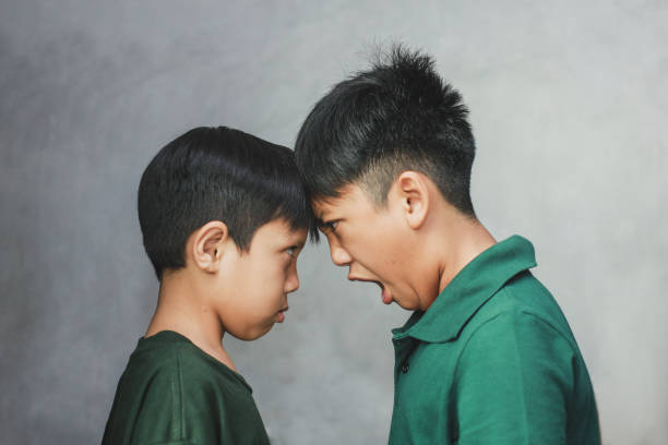 비명을 지르며 머리를 맞대고 싸우는 두 어린 소년, 클로즈업 - anger child furious asian ethnicity 뉴스 사진 이미지