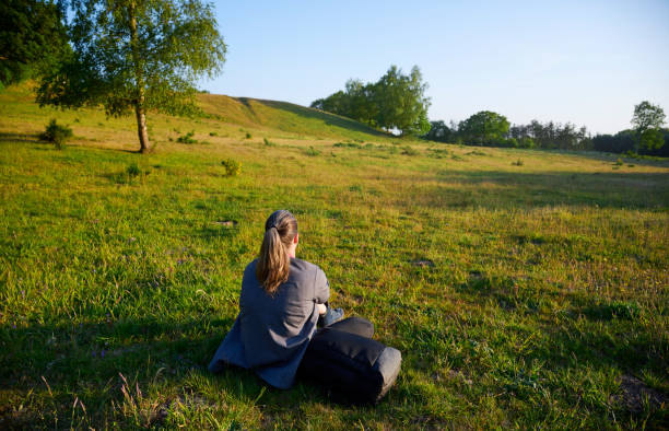 happy woman in a white short dress spins in a field next to an old wicker chair