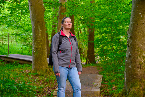 Mid adult woman trekking in Danish nature. Summertime front view portrait.