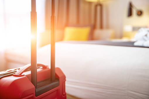 Background photo of hotel room interior with red suitcase