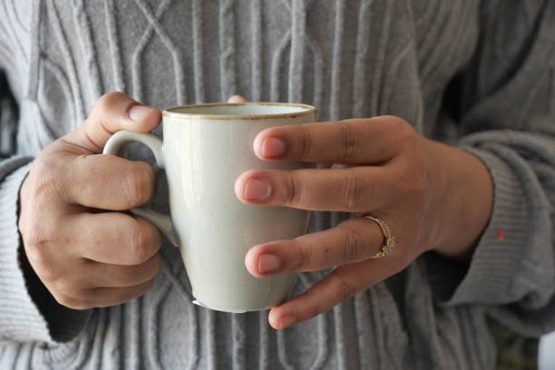 istock Close up of women's hand holding coffee mug 1496565389