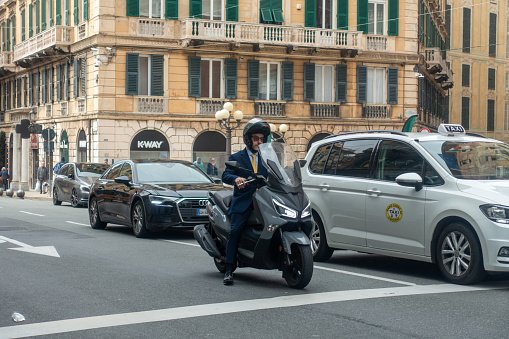 genoa italy may 20th 2023 man in suit rides his moped to work