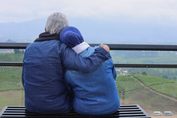 Rear view of senior couple embracing against nature background