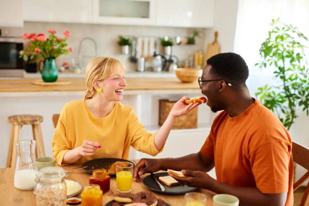 istock Multiracial couple enjoying breakfast together at home 1496568680