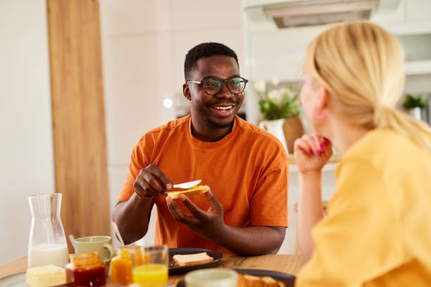 istock Multiracial couple enjoying breakfast together at home 1496568707