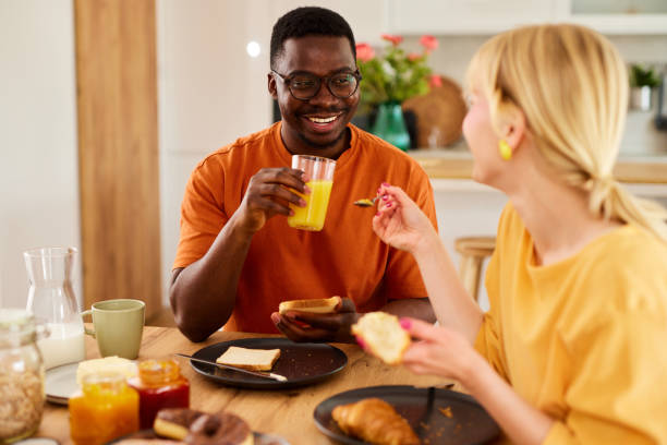 istock Multiracial couple enjoying breakfast together at home 1496568793