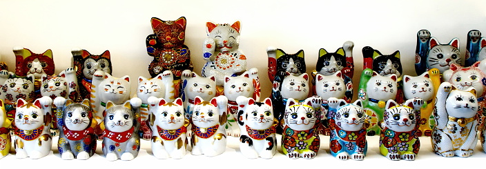 Maneki-neko cats, made of ceramic or plastic, for good luck and wealth, are a common Japanese figurine believed to bring good luck and wealth to the owner.