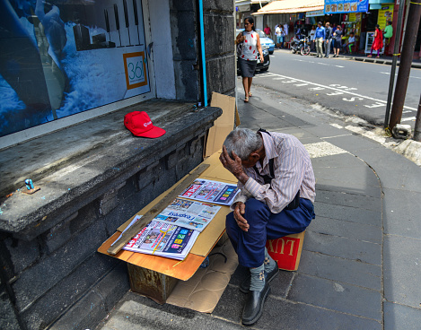 Port Louis, Mauritius - Jan 4, 2017. A man selling newspaper on street in Port Louis, Mauritius. Port Louis is the country economic, cultural and political centre.