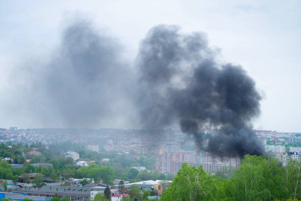 istock Black smoke rises over buildings and trees. Emergency concept. 1496573509