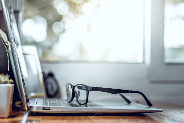 istock Eye glasses above laptop computer, Work from home, Business concept. 1496573764