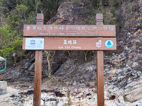 Hong Kong Unesco Global Geopark sign in Lai Chi Chong, a significant geosite with various rock types, including the rare volcaniclastic sedimentary rock, formed around 146 million years ago from falling volcanic ash that was mixed with silt and other organic deposits. It is a favourite destination for rock lovers with the only Permian stratum in Hong Kong.
