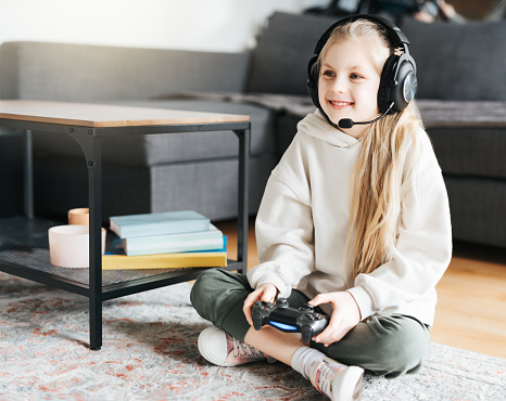 A little girl holding game controller playing video games