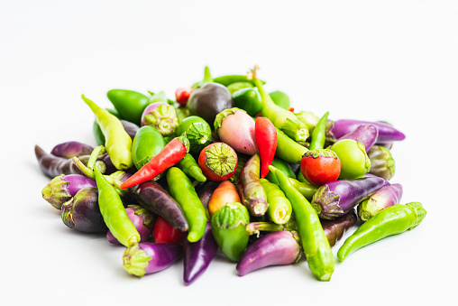 Green, purple and red hot peppers. Front view of pepper on white background.