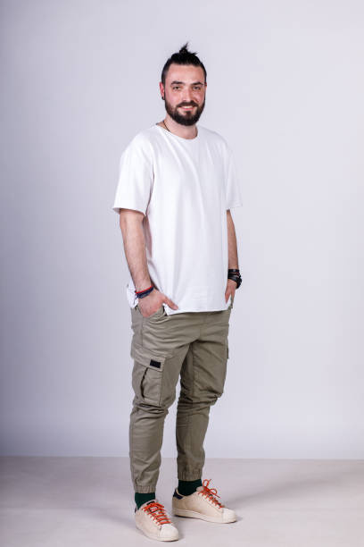 istock Charming young man standing against a white background, smiling at camera 1496589023