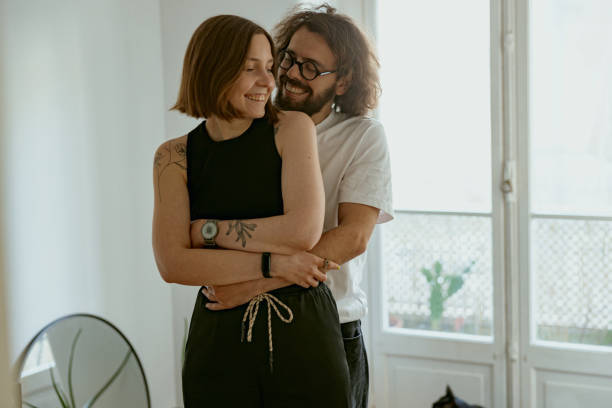 istock Smiling couple hugging and enjoying time together while standing at home. Good relationship time 1496589253