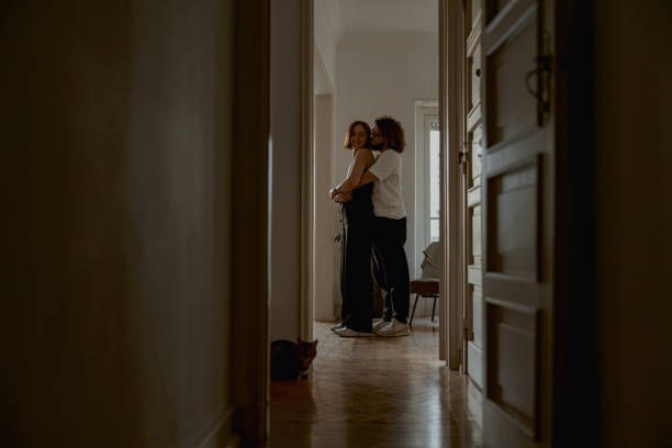 istock Romantic couple hugging and enjoying time together while standing at home. Good relationship time 1496589491