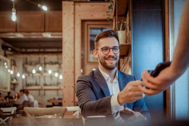 Put it on my card Elegant Male Dressed in a Suit Using Credit Card on Pos Terminal in Cafeteria paying stock pictures, royalty-free photos & images