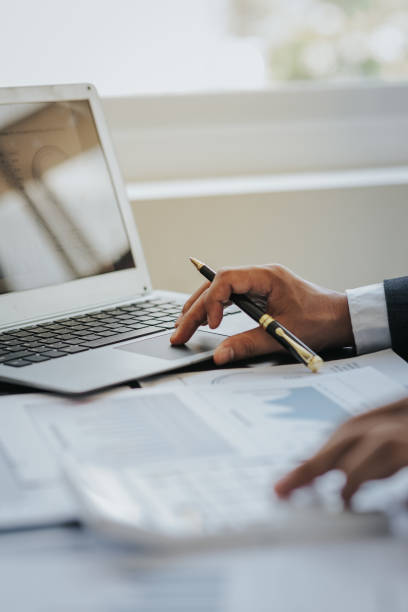 istock Close up work of businessman or accountant using calculator and laptop while analyzing business report in workplace financial planning and accounting concept 1496591231