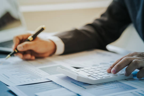 istock Close up work of businessman or accountant using calculator and laptop while analyzing business report in workplace financial planning and accounting concept 1496591261